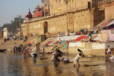 a group of people swimming in the water with Ganges in the background