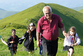 a group of people in a field with a mountain in the background