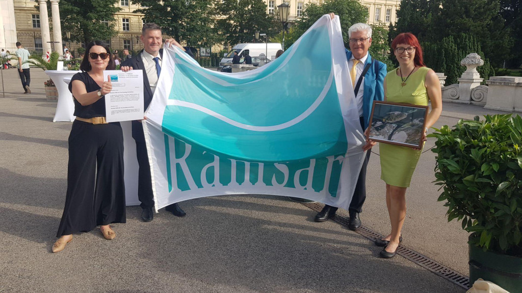 4 persons holding a fabric banner that says Ramsar
