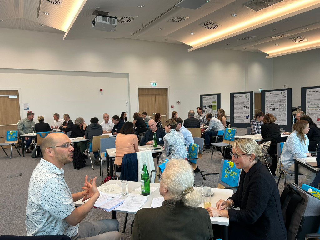 people sitting at tables in a large room in a workshop setting