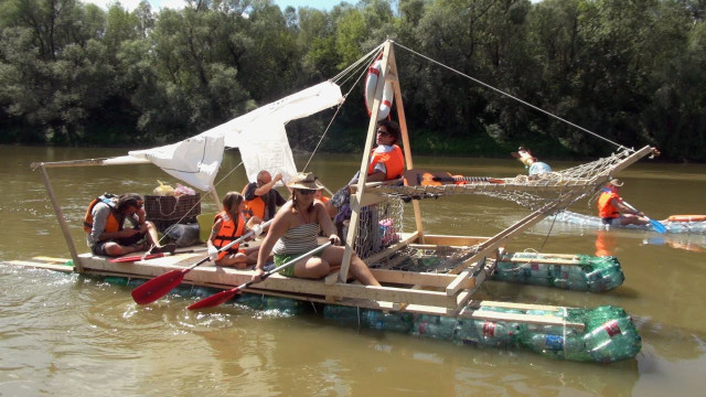 people working together to steer water bottle boat