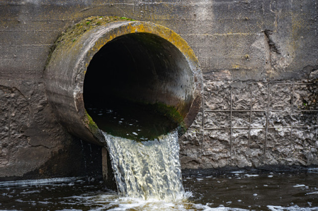 Pipe discharging untreated wastewater into a stream