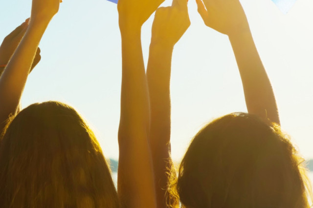 two girls giving their back to the camera, hold an EU flag