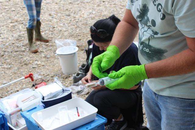 A person holding a water sample